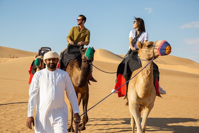 Dubai Evening Desert Safari: Sandboarding, BBQ, Camel Ride & more - Camel riding and sandboarding at the camp