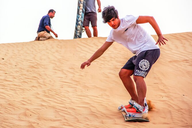 Dubai Private Sunset Desert Drive with Wildlife Experience - Learning to sandboard on orange dunes